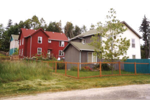 The three duplexes that make up Island Home East on a grassy slope.