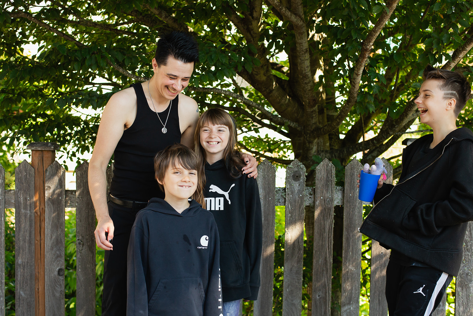 Housing Resources Bainbridge 2025 A father and four children laughing near a tree and fence
